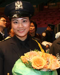 New NYPD graudate after the ceremony at Madison Square Garden, December 2006. She was the first in her family (who were all there) to become a police officer. Her husband brought the flowers to the ceremony for her. Photo by Pat Arnow