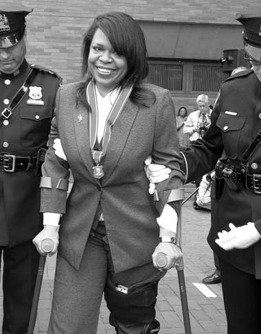 DETERMINED TO TRIUMPH: Retired Police Officer Isabelle Redman grins after receiving the Purple Shield at the NYPD's Medal Day. Ten years after being critically injured in the crash of her patrol car, Ms. Redman has started a second career as an Assistant District Attorney and lectures cops on safe driving. (6/25/04) 