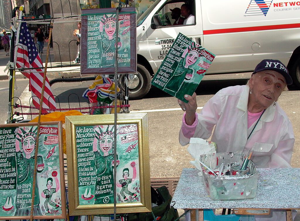 Bertha A. Halozan sells her paintings on the street in midtown. All the pictures feature the Statue of Liberty and the inscription, “We love Statue of Liberty There are still some good people Living in this world.”