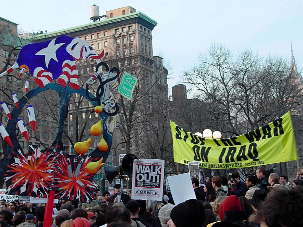 Union Square, Manhattan, protest against the impending Iraq War with sign of an elephant pooping bombs, 2003