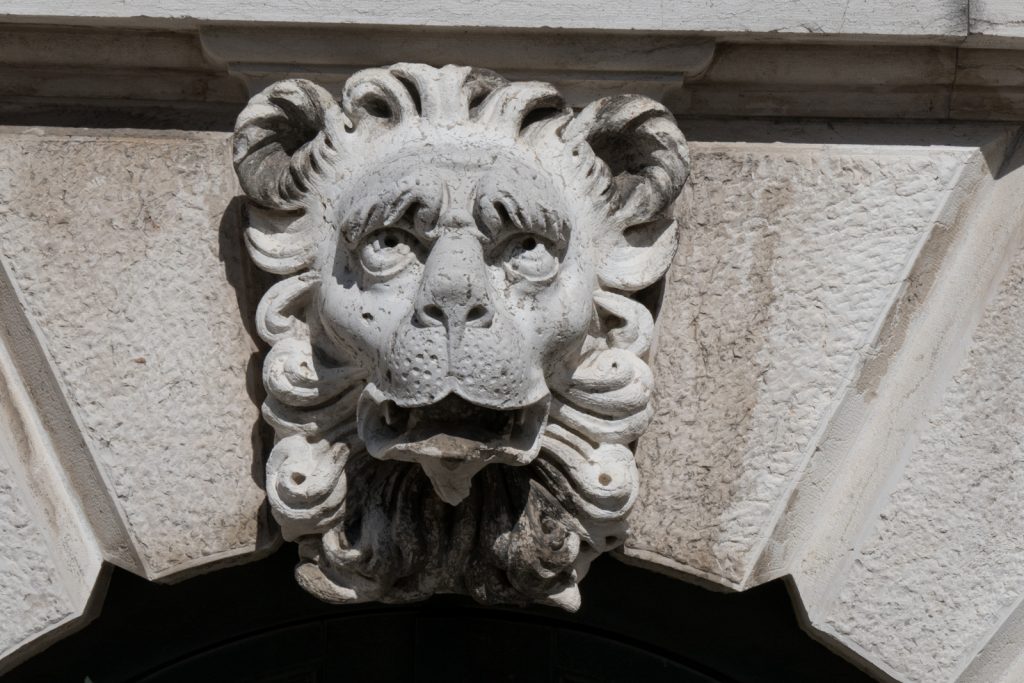 Stone lion head on Salute Basilica, Venice, seemingly rolling his eyes.