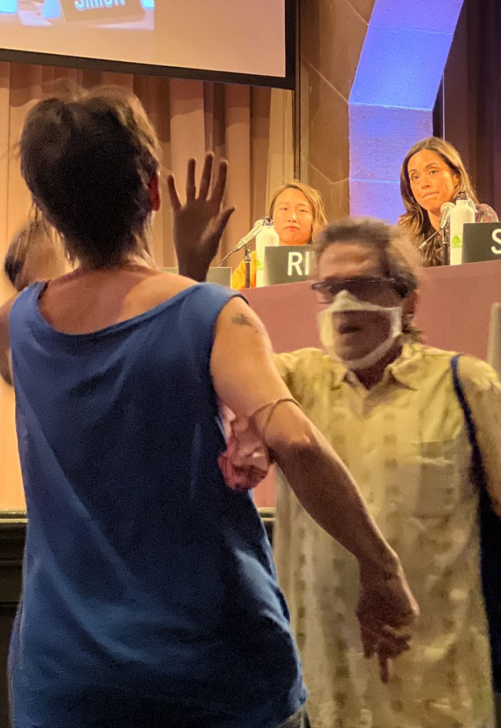 Photo: An East River Park activist confronted City Councilmember and District 10 congressional candidate Carlina Rivera, right, at a July 19 East Village forum on environmental issues. Rivera supporter Michael Schweinsburg of the 504 Democrats political club blocked the protester from getting any closer to the stage at The Cooper Union. PHOTO: PAT ARNOW